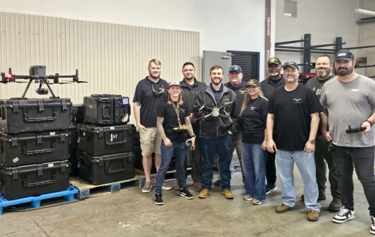 A group stands together with a drone