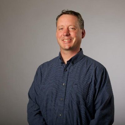 A man in a blue shirt smiling