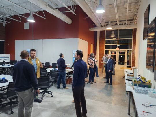 People chat in small groups throughout a large room